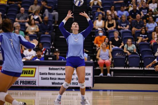 Volleyball player with hands in the air spiking volleyball