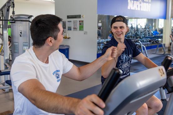Student and relative working out together at campus rec