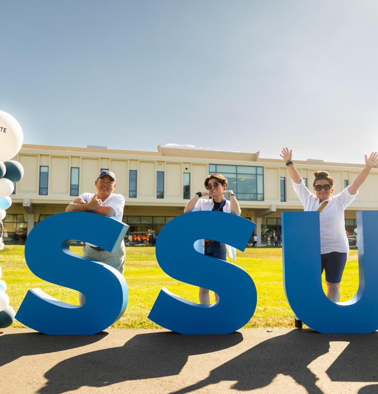 Parents and student standing infront of SSU letters