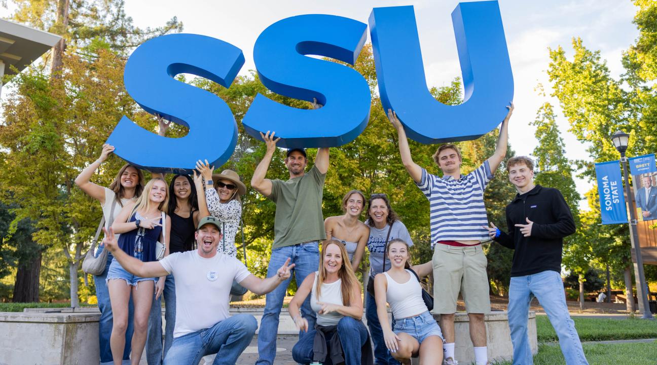Large group of students holding large SSU letters in the air