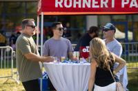 Group of people socializing and talking at the beer and wine garden at a table