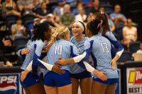 Group of volleyball players huddled hugging