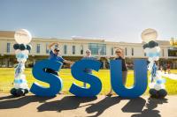 Two parents and a studnet standing infront of SSU letters