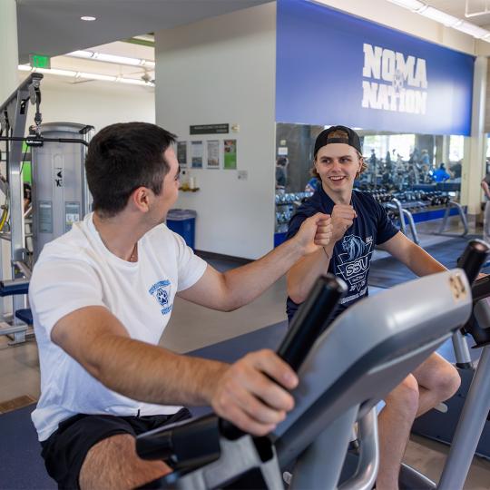 Student and relative working out together at campus rec