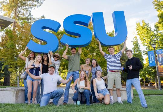 Large group of students holding large SSU letters in the air