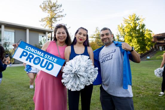 Two parents and student holding Sonoma State Proud signs