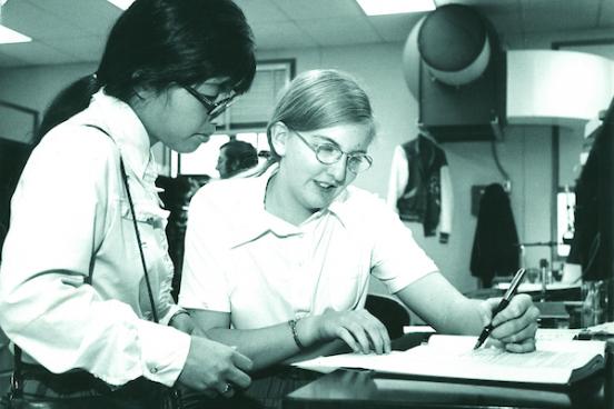 Historic photo of two SSU Students looking at a book