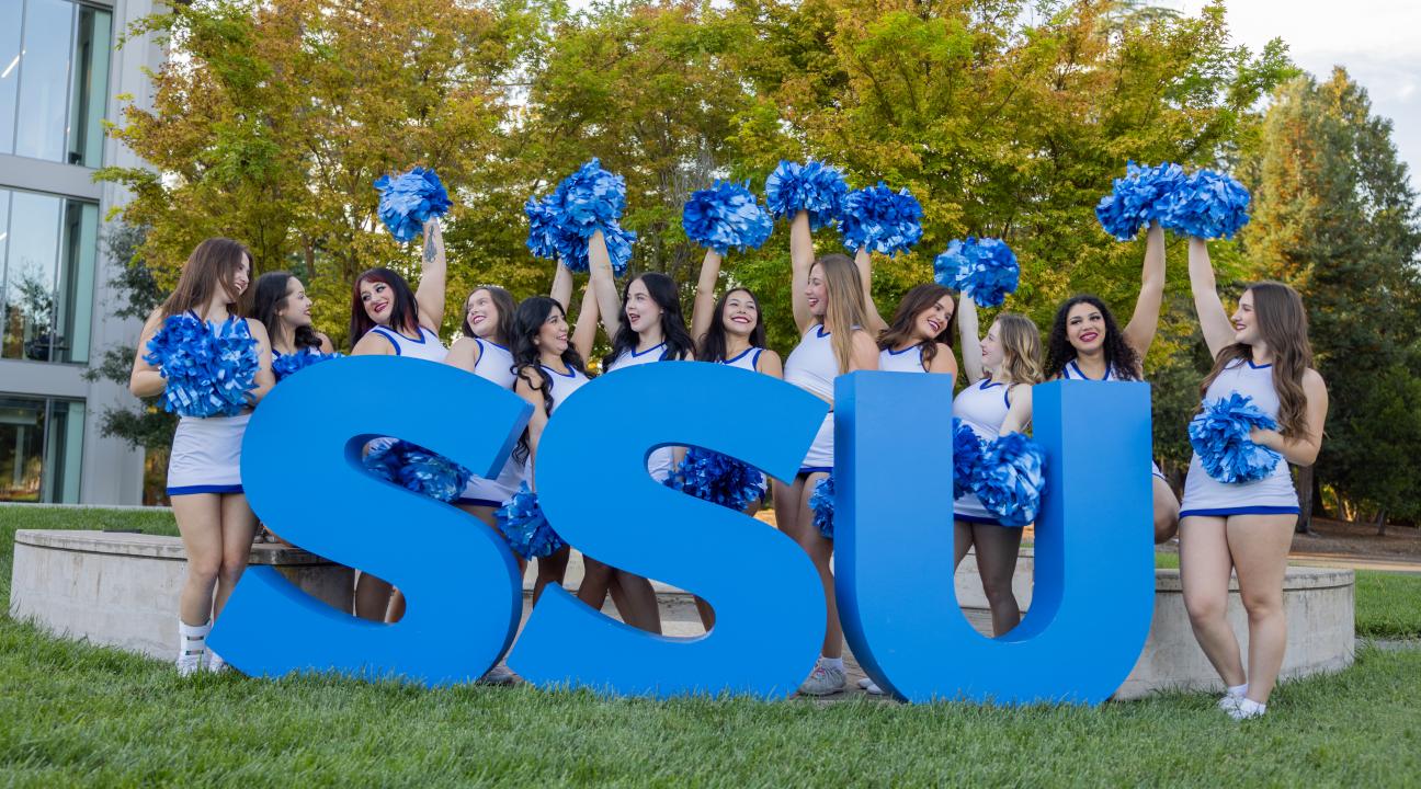 SSU large letters with group of cheerleaders with pom poms in air