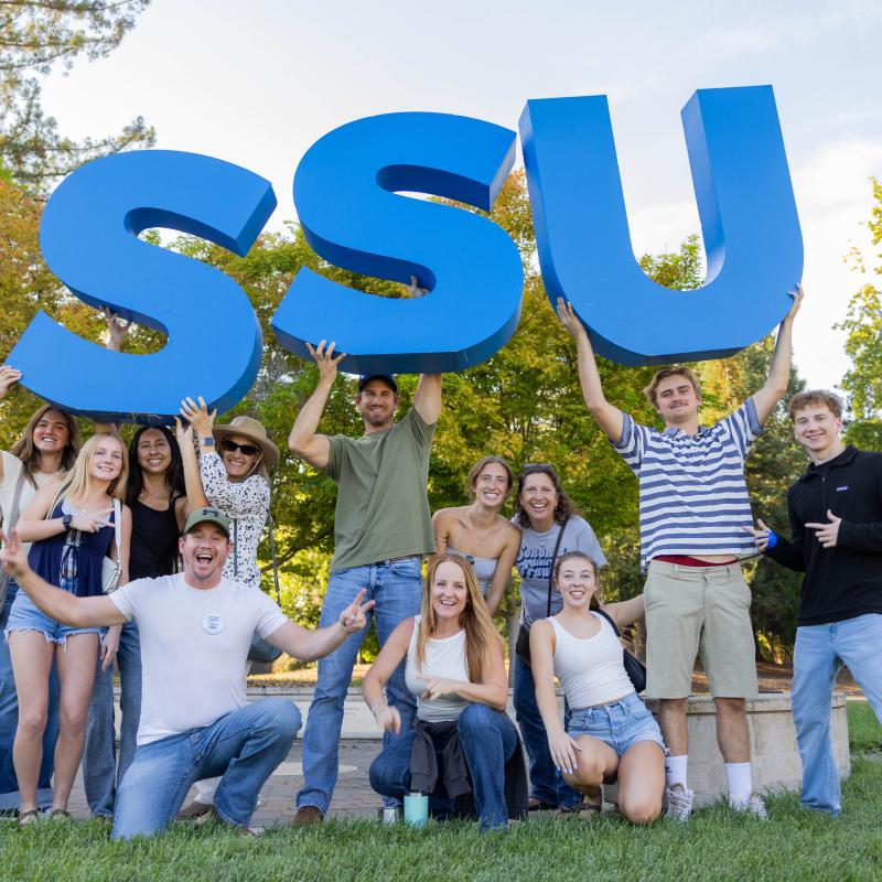 Large group of students holding large SSU letters in the air