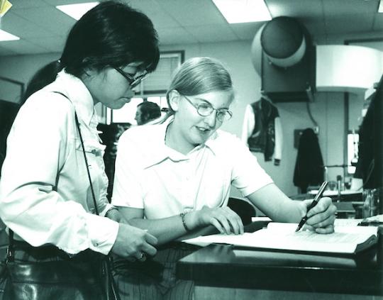 Historic photo of two SSU Students looking at a book